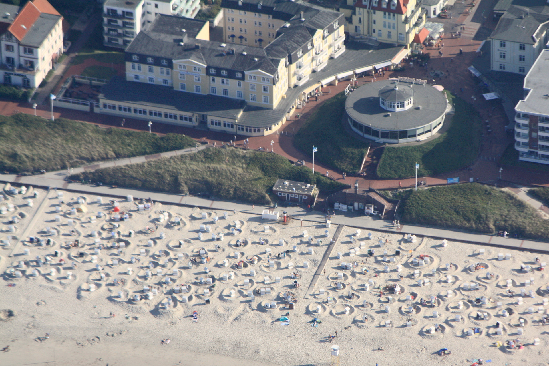 Luftbild vom Strand von Wangerooge. Man sieht das Café Pudding von oben und viele Strandkörbe.